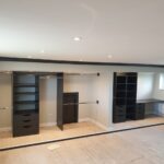 Sliding wardrobe colour matched interior. Contains Shelving, hanging rails, drawers, and desk