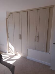 bespoke fitted shaker style wardrobes with a sloping ceiling and a stair bulkhead