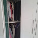 Corner wardrobe interior with curved hanging rail maximising storage space.