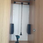 Accessible wardrobe pull-down hanging rail lowered to reachable height.