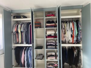 Bespoke wardrobe interior with clothes hanging rails, fixed shelving and top shelves
