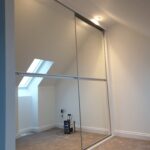 Minimalist sliding door wardrobe with mirrors fitted.