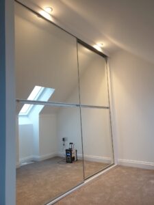 Minimalist sliding door wardrobe with mirrors fitted.