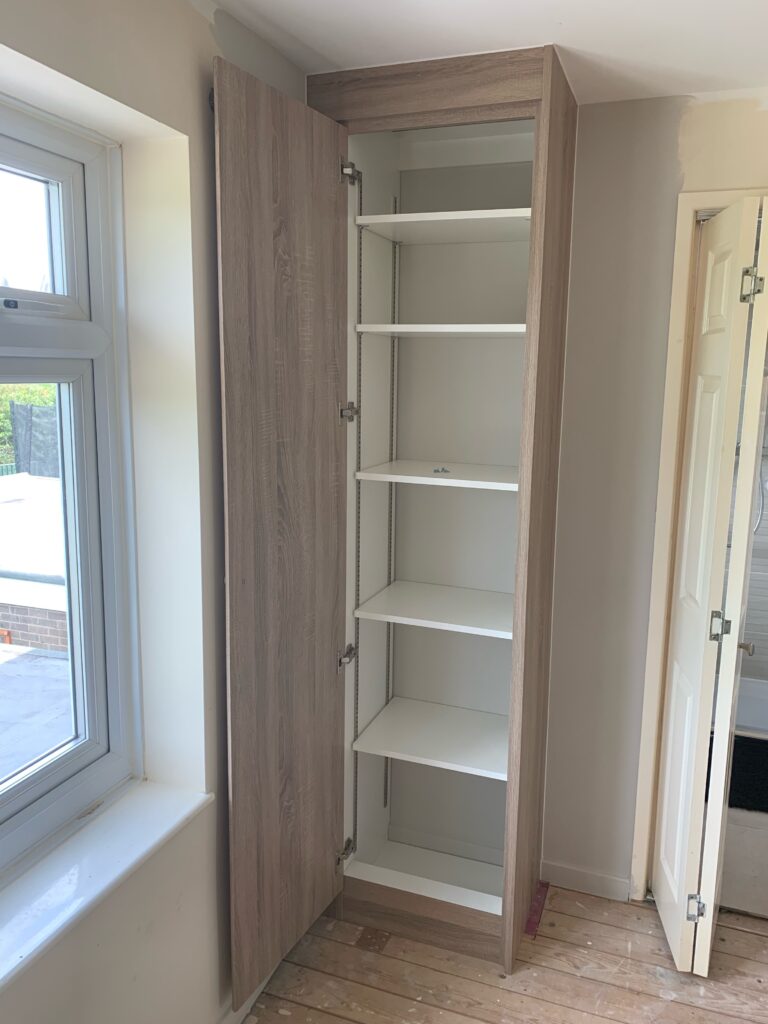 Wardrobe interior with adjustable shelves on bookcase strip supports.
