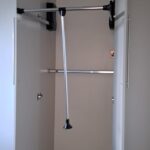 Accessible wardrobe pull-down hanging rail lowered to reachable height. - White