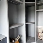 grey corner wardrobe with shelves, hanging rails, and drawers
