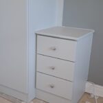 bespoke fitted bedside table, fitted to a wardrobe. Cashmere colour finish. the drawers have knob handles fitted and are in the colour Cashmere