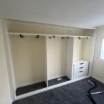 Interior of a shallow sliding door wardrobe with front to back pull out hanging rails and drawers