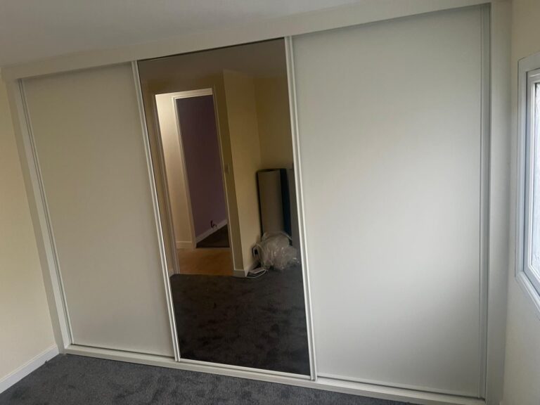 Bespoke sliding door wardrobe with one Bronze Mirrored door and two White panelled doors fitted in a park home