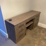 bespoke fitted dressing table in brown wood colour finish. There is a matching stool