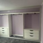 Interior of a shallow sliding door wardrobe with front to back pull out hanging rails and drawers