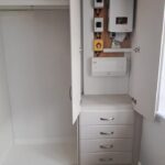 Bespoke fitted boiler cupboard in bedroom with four drawers below