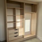 Wardrobe interior featuring fixed shelving for folded clothes and organised storage