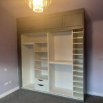 Wardrobe interior featuring fixed shelving for folded clothes and organised storage.