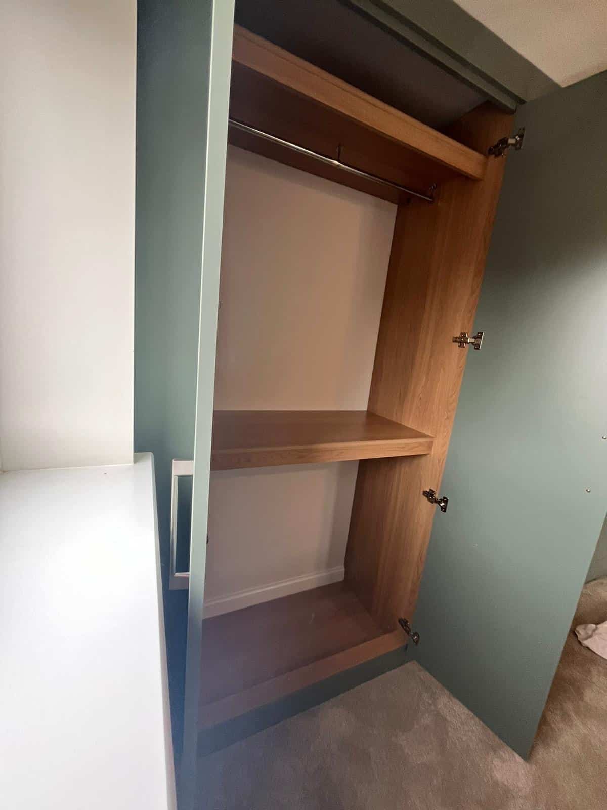 Bespoke fitted wardrobe interior with a top shelf and two hanging rails in an oak finish