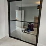 Bespoke fitted sliding door wardrobes with grey tinted mirrors - minimal and sophisticated