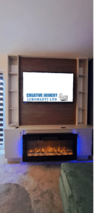 Fitted media wall in a living room with an electric fire