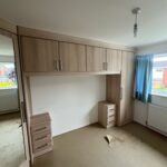 Bridge over bed and corner wardrobe fitted in the Oslo style, Sonoma Oak colour finish