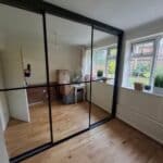 3 door black framed sliding door wardrobe with full length mirrors