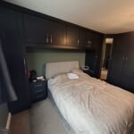 Bridge over bed and corner wardrobe fitted in the Shaker style, Indigo Blue colour finish