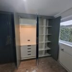Wardrobe hanging rails fitted beneath a top shelf for everyday clothing storage
