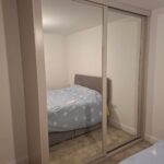 fitted Shaker wardrobes with mirrored sliding doors in the colour Cashmere
