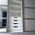 fitted sliding door wardrobe interior with four drawers and shelving