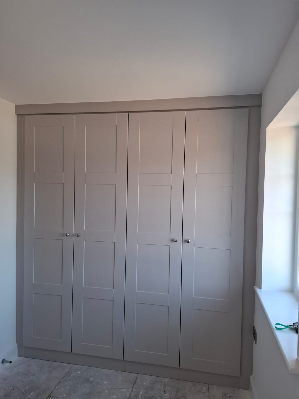 Two double wardrobes fitted wall to wall. The wardrobe doors are in the shaker style and in the colour Cashmere Grained.