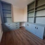 Bespoke home office in the colour Reed Green. Office drawers, office cupboards and a curved office desk are fitted. Adjustable bookcase shelving is fitted above all the drawers and cupboards. The cupboards and drawers are in the Shaker style.