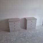 Two stand alone bedside tables, each with three drawers. Knob handles are fitted to the centre of each drawer. The colour is Cashmere Grained