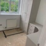 Bespoke home office ith a floor to ceiling double cupboard and a curved desk. Under the curned desk at each side is a chest of three drawers. The furniture is fitted. The doors and drawers are in the Mercia style. This is a slim shaker look.