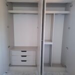 Fitted wardrobe interior with hanging space and drawers.