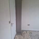 Bespoke Shaker Stone Grey floor to ceiling cupboard fitted to a wall on the right. Knob handles are fitted.