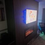 bespoke media wall with acoustic wall paneling and an intergrated electric fire. fitted by Creative Joinery