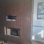 progress of the building of a custom media wall with fire intergration and acoustic wall panelling