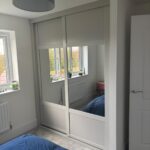 made to measure alcove wardrobes in the colour Light Grey. The shaker sliding doors are fitted with a mixture of mirrors and panels