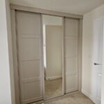 bespoke sliding door wardrobe with Shaker style panelled doors and a mirrored door
