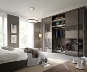 Pebble Grey Harrison Monarch sliding door wardrobe featuring Bronze Tinted Mirror panels in a modern bedroom interior.