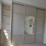 Bespoke shaker sliding door wardrobe and custom shaker drawers with shelving n the colour Cashmere by Creative Joinery