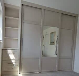 Bespoke shaker sliding door wardrobe and custom shaker drawers with shelving n the colour Cashmere by Creative Joinery