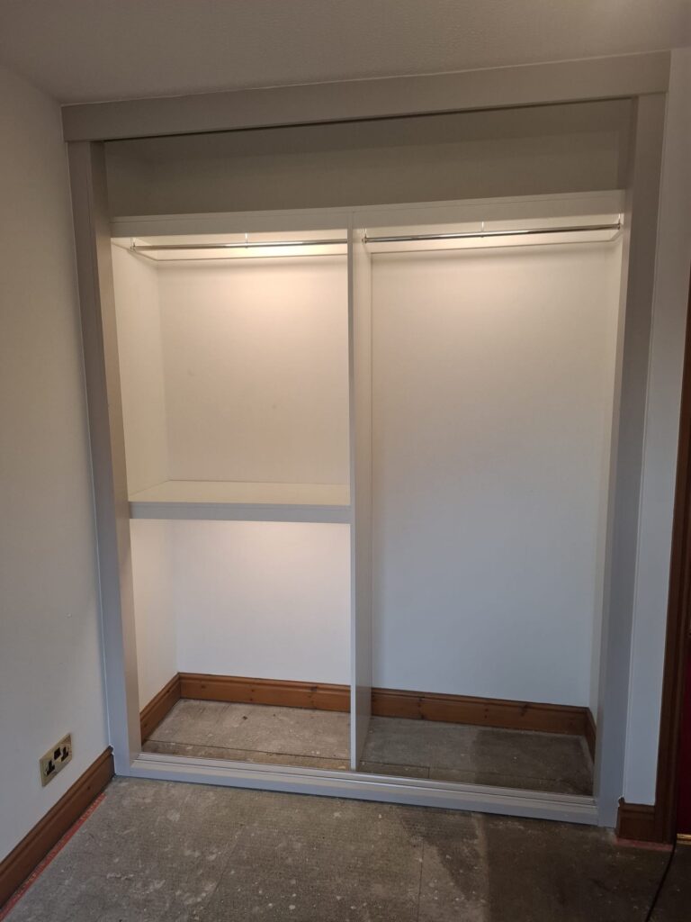 Wardrobe hanging rail fitted beneath a top shelf for everyday clothing storage