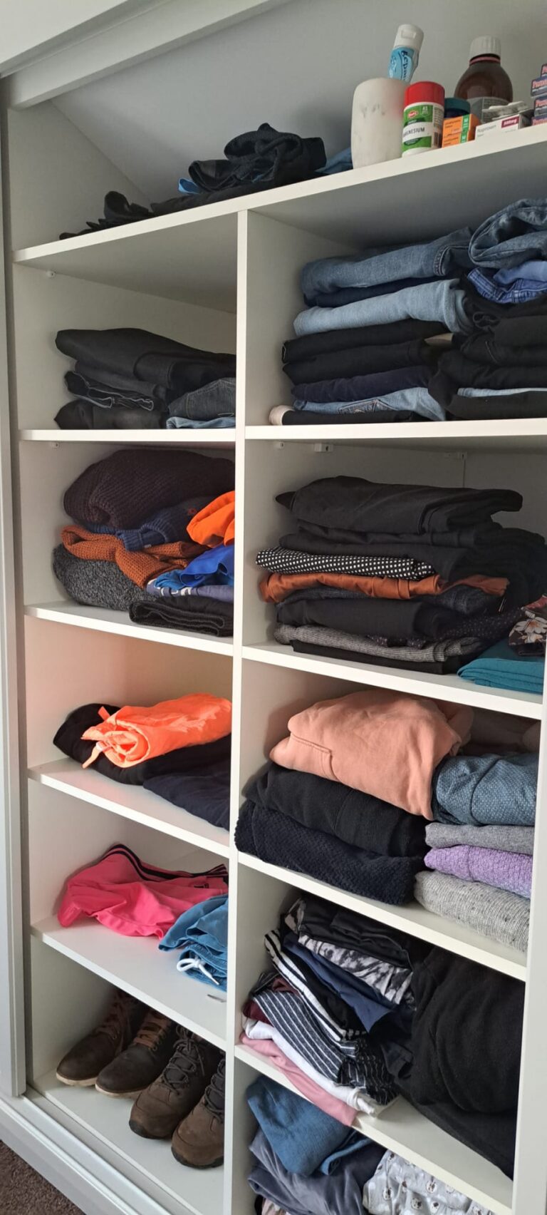 Wardrobe interior featuring fixed shelving for folded clothes and organised storage