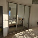 3 door sliding wardrobe with white wood frame and 3 mirrored doors