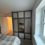 Custom Shaker sliding doors with a combination of textures neutral grey panels, stone grey coloured glass and bronze tinted mirror