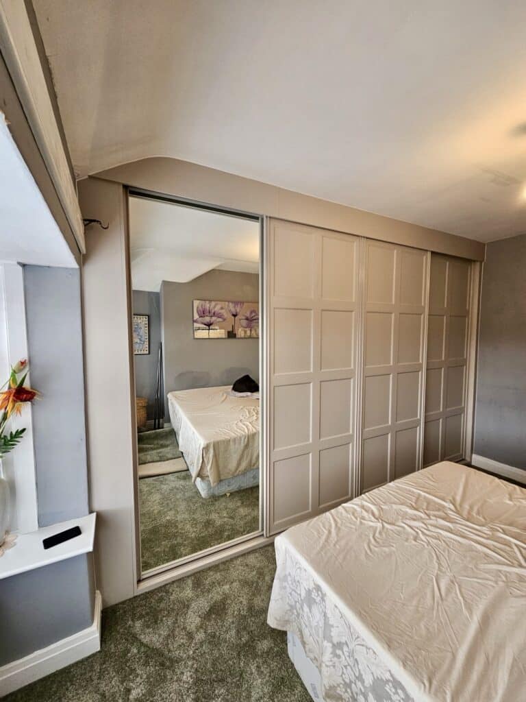 Custom Shaker sliding door wardrobe in neutral colour finish by Creative Joinery Chorley.
