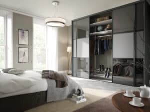 4 door sliding wardrobe with dark grey and light grey panels. open to show shelves and hanging rail