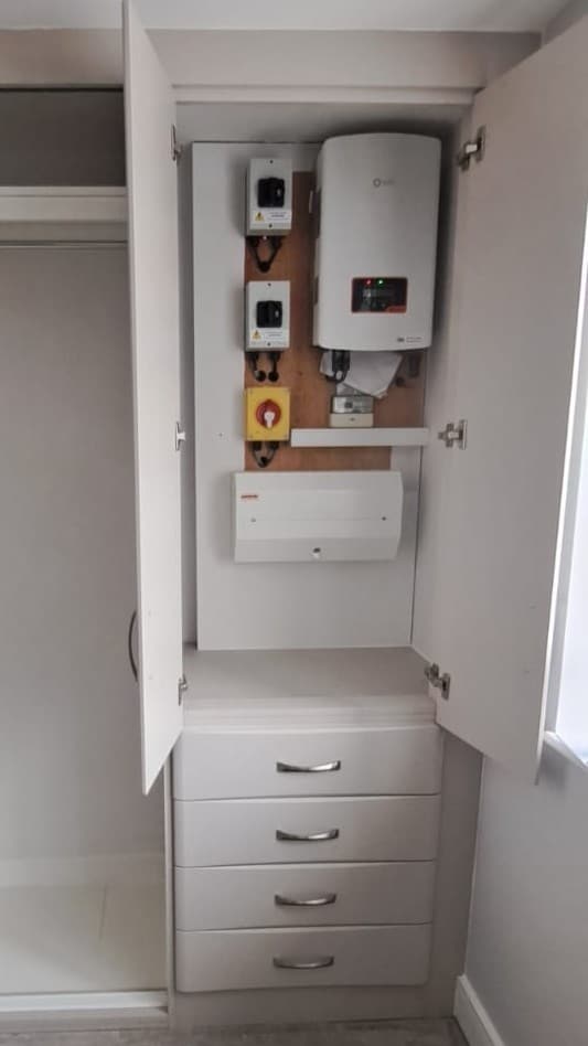Custom boiler cupboard with drawers below incorporated into bespoke bedroom furniture