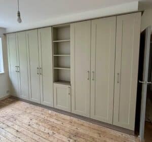 Replacement bespoke wardrobe doors in the Shaker style, Neutral finish with the addition of a shelving unit.