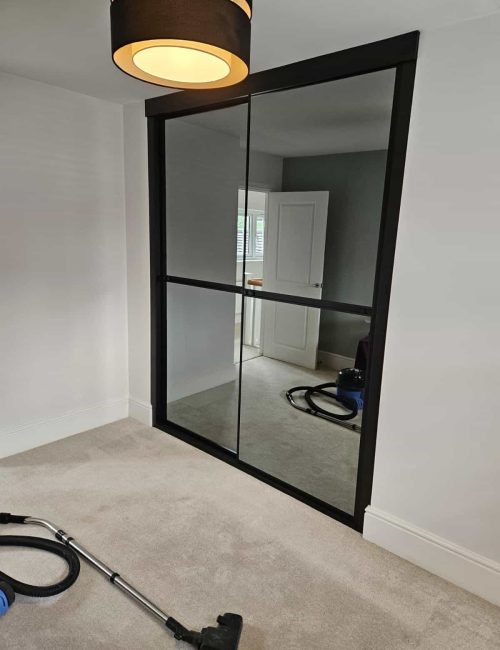 Bespoke fitted sliding door wardrobes with grey tinted mirrors