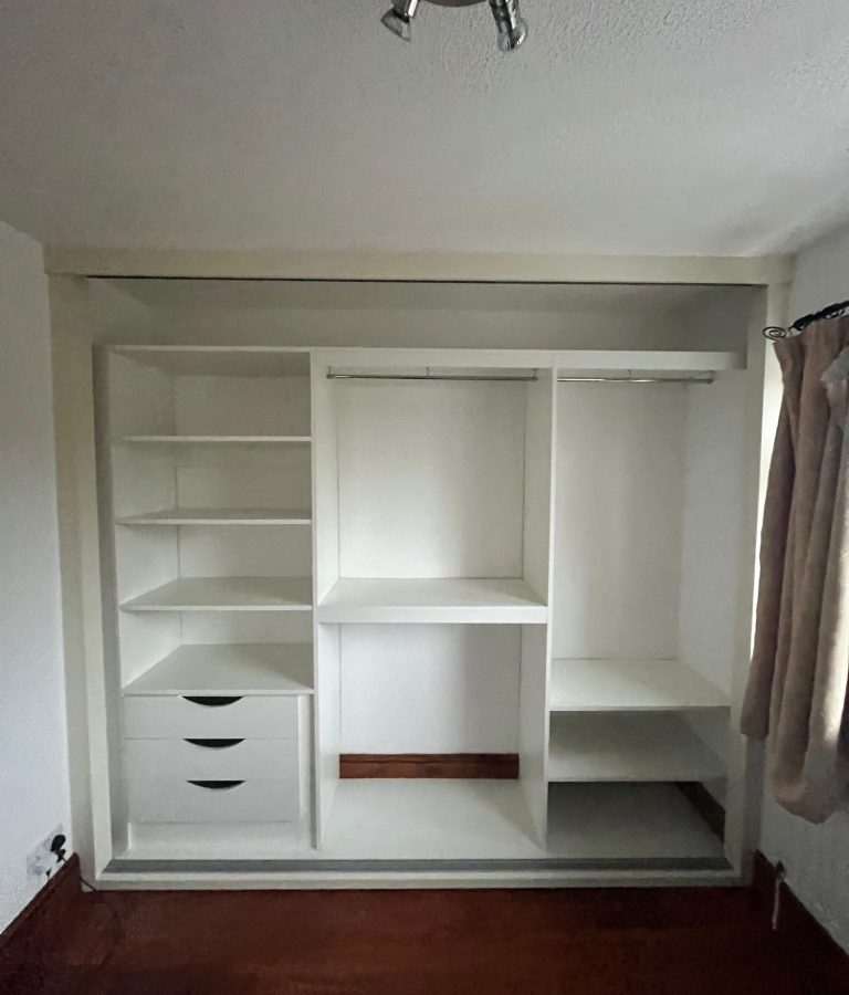 Wardrobe interior with a full-width top shelf for overhead storage.